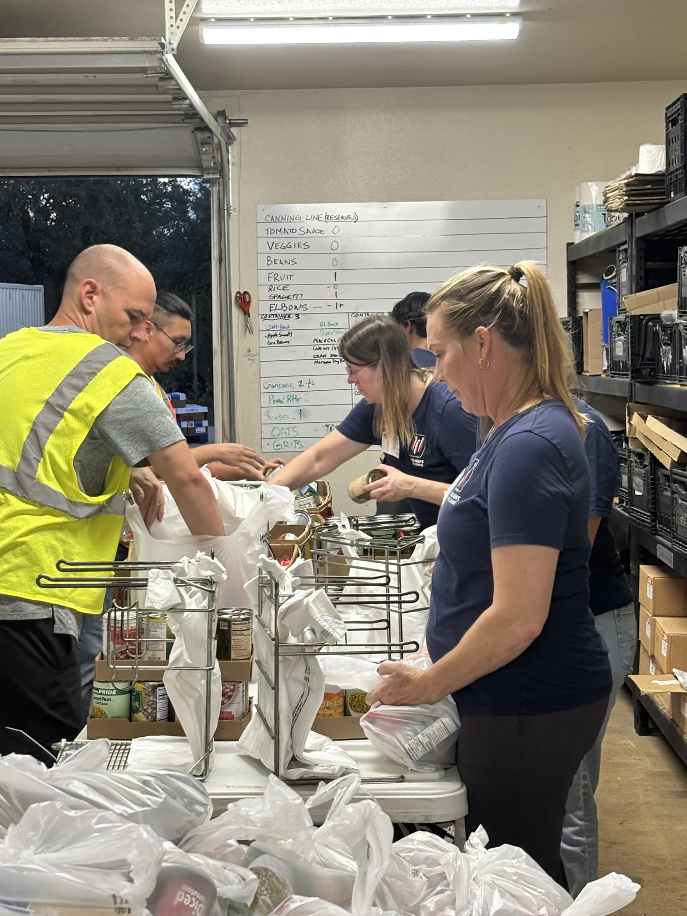 Reveal volunteers packing food bags together in the pantry.